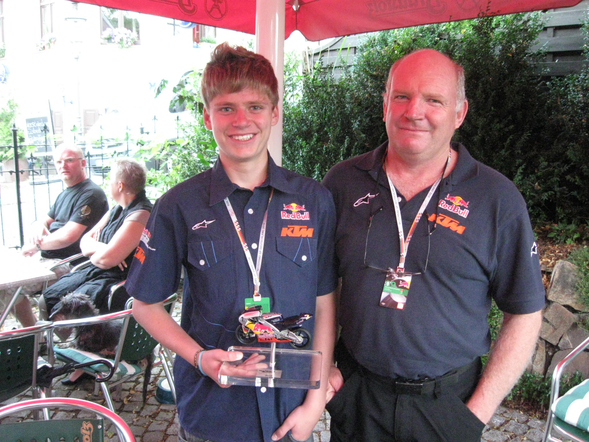 Brad Binder adds some more hardware to his shelf. Proud dad Trevor stands by.